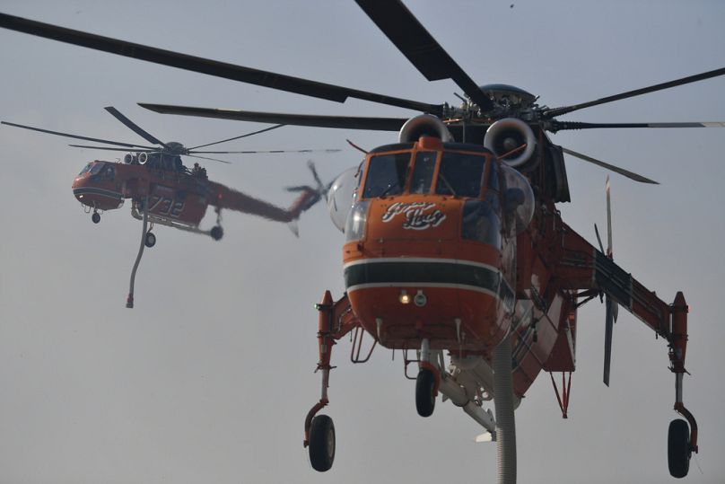 Zwei Löschhubschrauber im Einsatz bei Penteli, nordöstlich von Athen, Griechenland, Montag, 12. August 2024. 