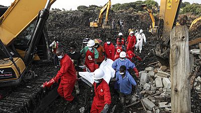 Red Cross personnel carry the body of a victim at the site of a collapsed landfill in Kampala, Uganda, Sunday, Aug. 11, 2024.