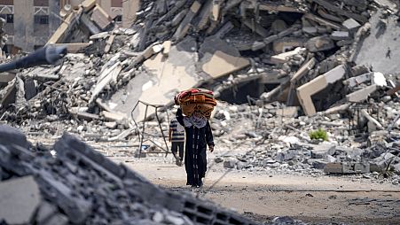 A Palestinian displaced woman flees from Hamad City, following an evacuation order by the Israeli army to leave parts of the southern area of Khan Younis, Sunday, Aug. 11, 202