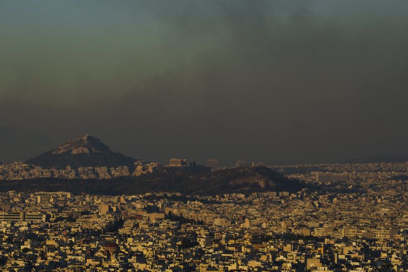 Una vista generale di Atene con la collina dell'Acropoli mentre il fuoco brucia la parte settentrionale della città, 12 agosto 2024