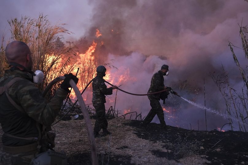 Des volontaires luttent contre les flammes dans le nord d'Athènes, en Grèce, le lundi 12 août 2024.