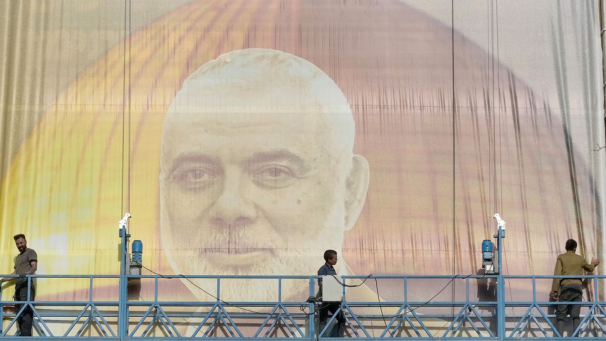 FILE: Iranian workers install a huge banner on a wall showing a portrait of Hamas leader Ismail Haniyeh in Tehran, 31 July 2024