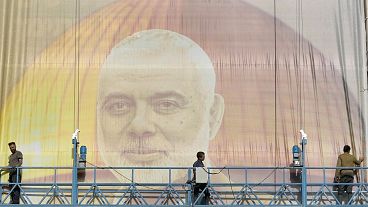 FILE: Iranian workers install a huge banner on a wall showing a portrait of Hamas leader Ismail Haniyeh in Tehran, 31 July 2024 FILE: Iranian workers install a huge banner on a wall showing a portrait of Hamas leader Ismail Haniyeh in Tehran, 31 July 2024