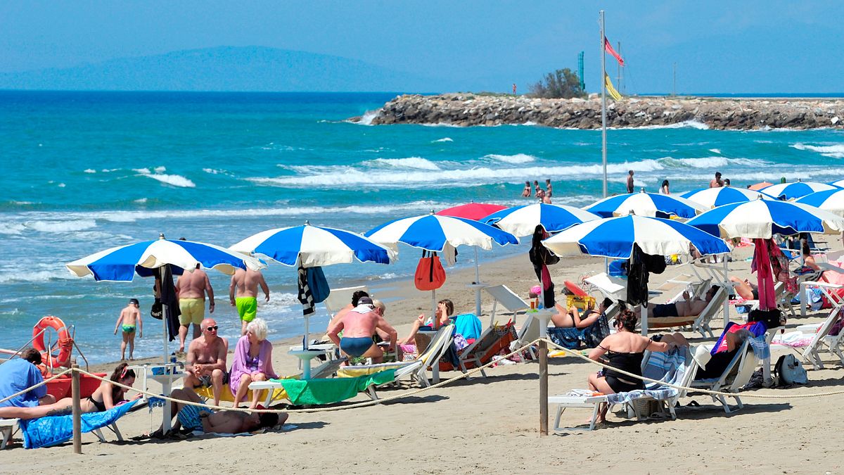 FILE - People enjoy a sunny day at an establishment on the beach in Tuscany's Castiglione della Pescaia, 24 May 2020