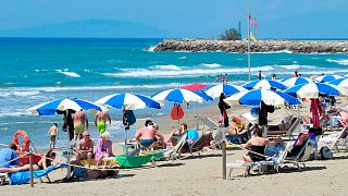 FILE - People enjoy a sunny day at an establishment on the beach in Tuscany's Castiglione della Pescaia, 24 May 2020