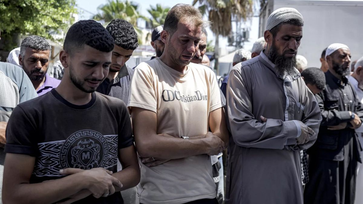 Mohammad Abu Al-Qumsan, au centre, prie à côté des corps de ses jumeaux âgés de 4 jours, tués lors du bombardement israélien de la bande de Gaza, mardi 13 août 2024.