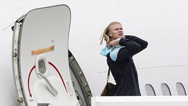 Manchester City's Erling Haaland disembarks from a plane.