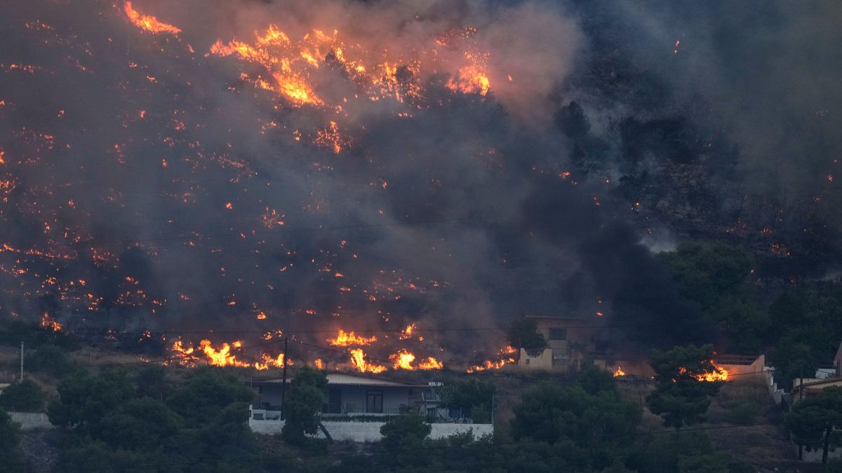 Fire approaches houses in Kalamaki near Agioi Theodori about 60 Kilometres west of Athens.