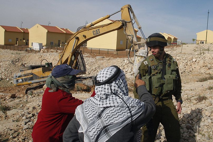 Palästinenser streiten mit einem israelischen Soldaten während einer Demonstration gegen die Erweiterung der israelischen Siedlung Carmel südlich von Hebron, 26. April 2009 