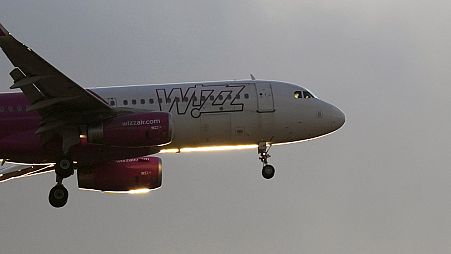 A Wizz Air Airbus A320 approaches for landing in Lisbon at sunset in July