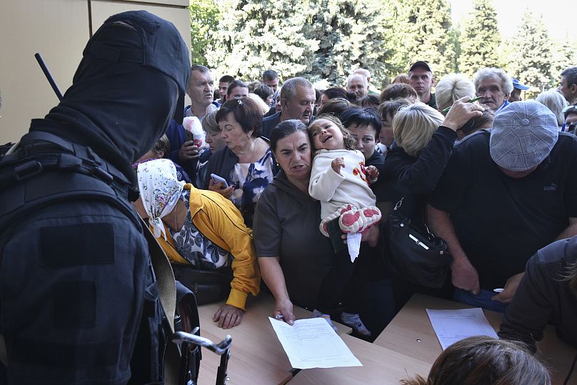 Evacuated people in the Kursk region queue to fill out the form for humanitarian aid at a humanitarian aid distribution centre in Kursk.