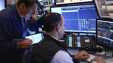 Trader Michael Milano. left, works with colleagues on the floor of the New York Stock Exchange, Wednesday, Aug. 7, 2024. 