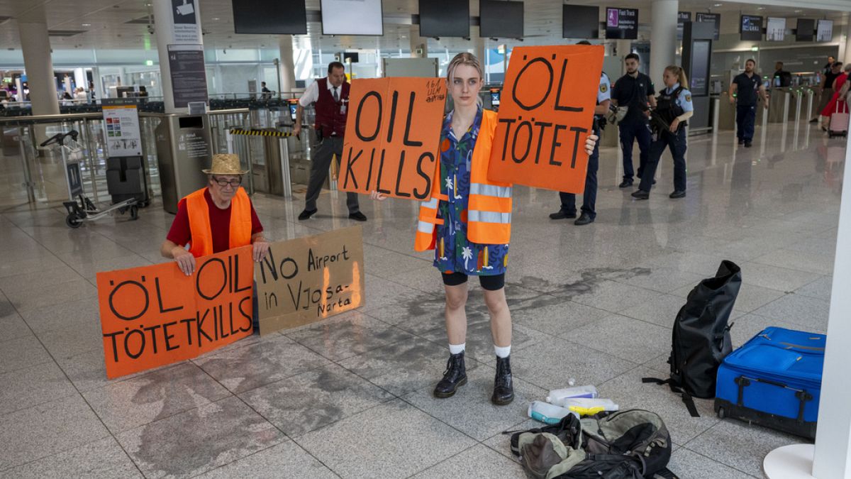 Des membres de "Dernière génération" participent à une manifestation à l'aéroport de Munich, Allemagne, le mercredi 14 août 2024.