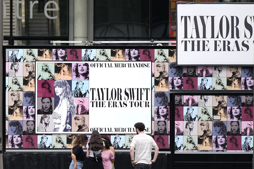 Una familia mira un quiosco de 'merchandising' de Taylor Swift en el estadio de Wembley en Londres, el miércoles 14 de agosto