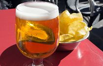 Beer and crisps on a terrace table.