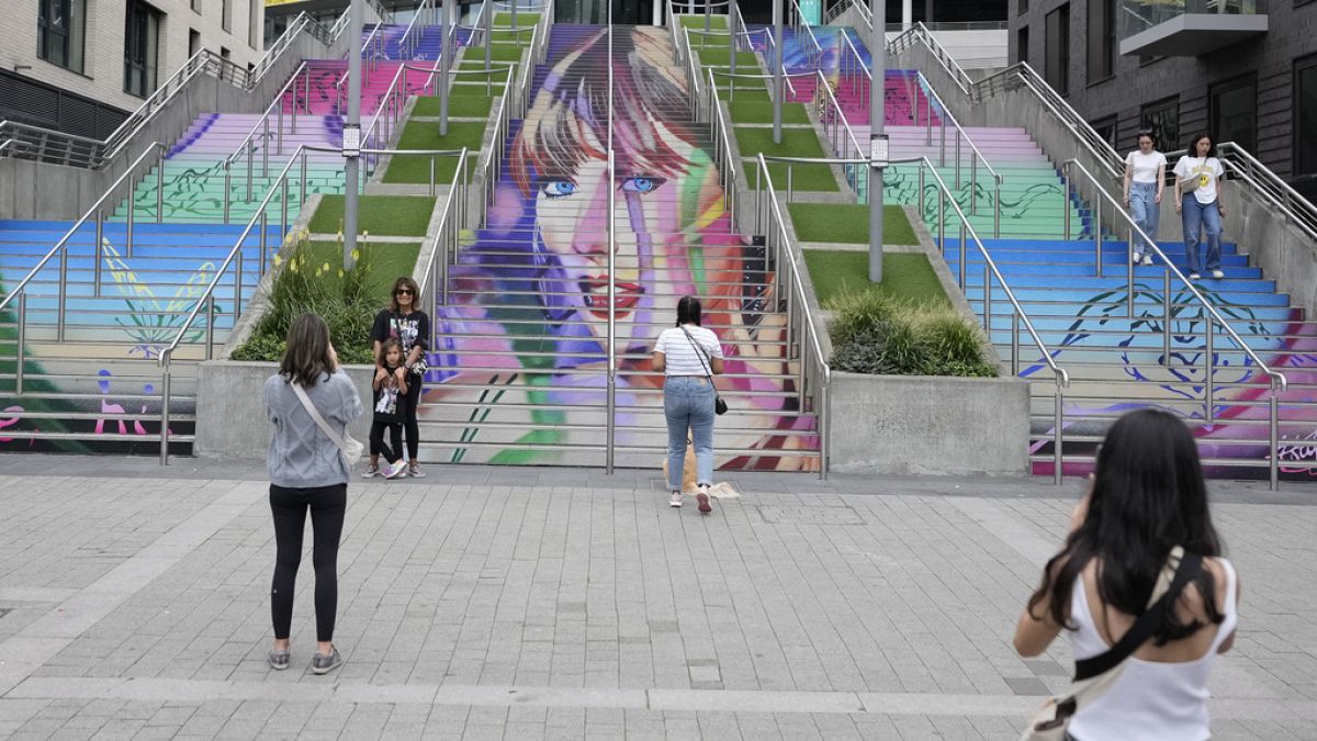 Unas fans posan junto a un retrato de Taylor Swift pintado en una escalera en el estadio de Wembley en Londres, el miércoles 14 de agosto de 2024