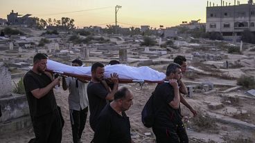 Un grupo de palestinos traslada hacia el cementerio el cuerpo de una víctima de los ataques israelíes, en Deir al-Balah (Gaza), el pasado viernes.