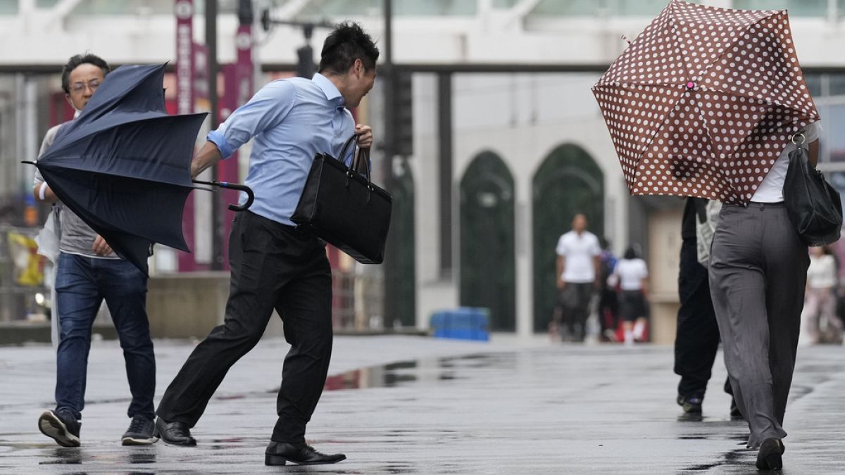 Un homme tenant un parapluie lutte contre un vent fort alors que le typhon Ampil s'approche de la région de Tokyo, au Japon, le vendredi 16 août 2024. 