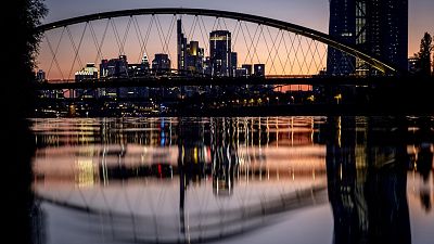 The European Central Bank and the banking district are reflected in the river Main after sunset in Frankfurt