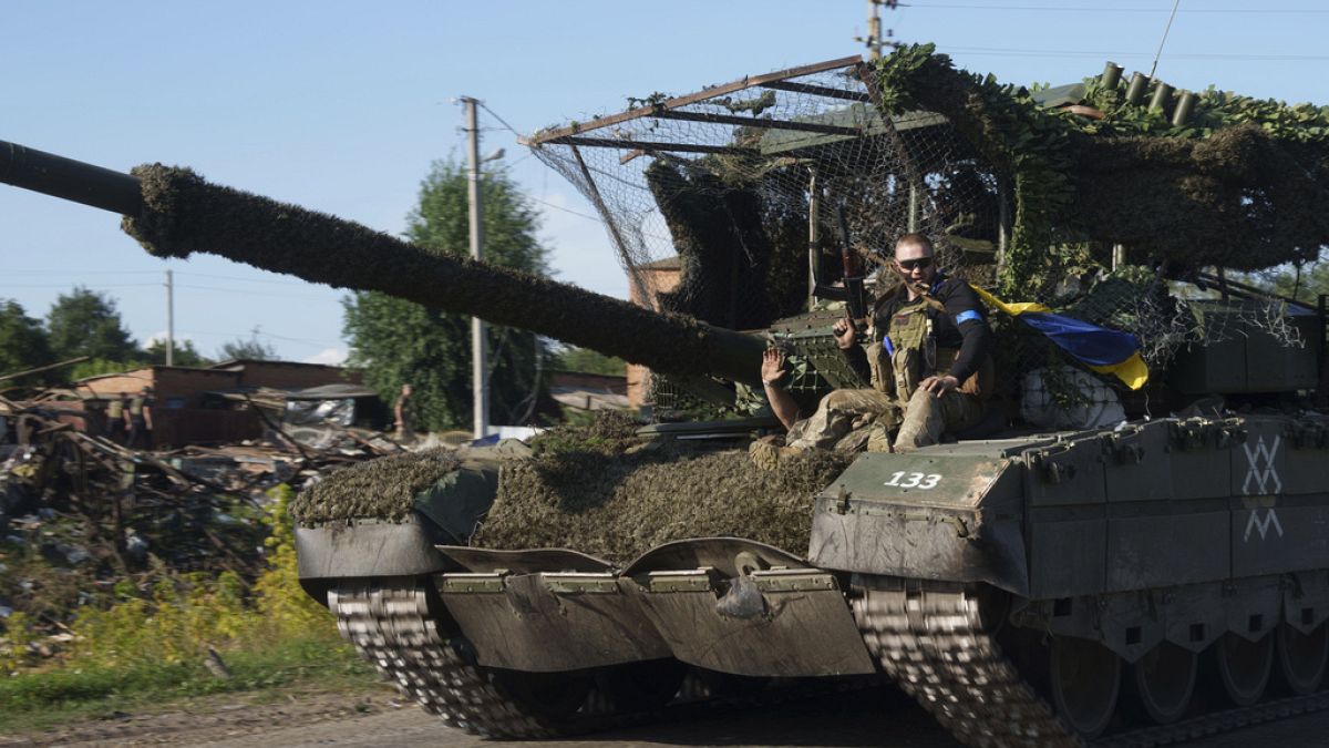 Ein ukrainischer Soldat fährt auf einem Trophäenpanzer, nachdem er aus Russland in der Nähe der russisch-ukrainischen Grenze in der Region Sumy, Ukraine, zurückgekehrt ist.