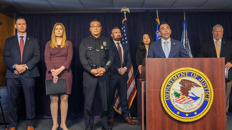 United States Attorney Martin Estrada, at podium, is joined by officials to announce  court filings related to the death of actor Matthew Perry