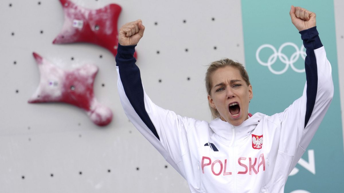 Gold medallist Aleksandra Miroslaw of Poland celebrates on the podium after winning the women's speed climbing final at the 2024 Olympics, Aug. 7, 2024, in Le Bourget, France