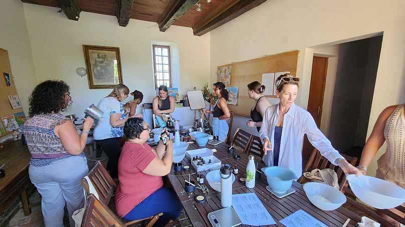 As mulheres desfrutam de uma aula de fabrico de bombas de banho.