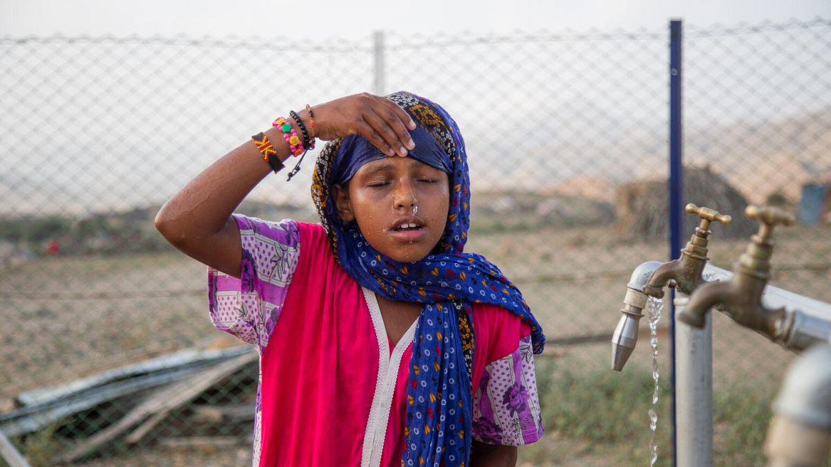 7-year-old Madina Mohamed Awad faces her face with clean water at a new water station in the small village of Gelhanty in Sudan