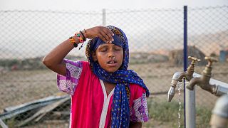 7-year-old Madina Mohamed Awad faces her face with clean water at a new water station in the small village of Gelhanty in Sudan