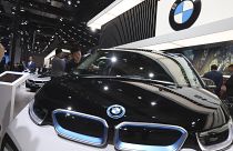 A worker cleans an electric vehicle at the BMW booth during the Auto Shanghai 2019 show in Shanghai on April 17, 2019. (AP Photo/Ng Han Guan, file)