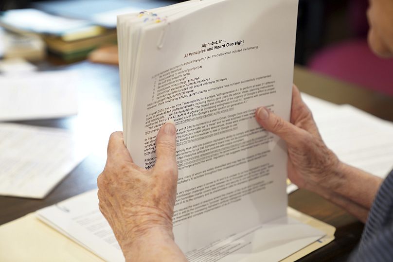 Sister Barbara McCracken looks through prior resolutions filed against various corporations, including Alphabet, Meta, Netflix and Chevron.