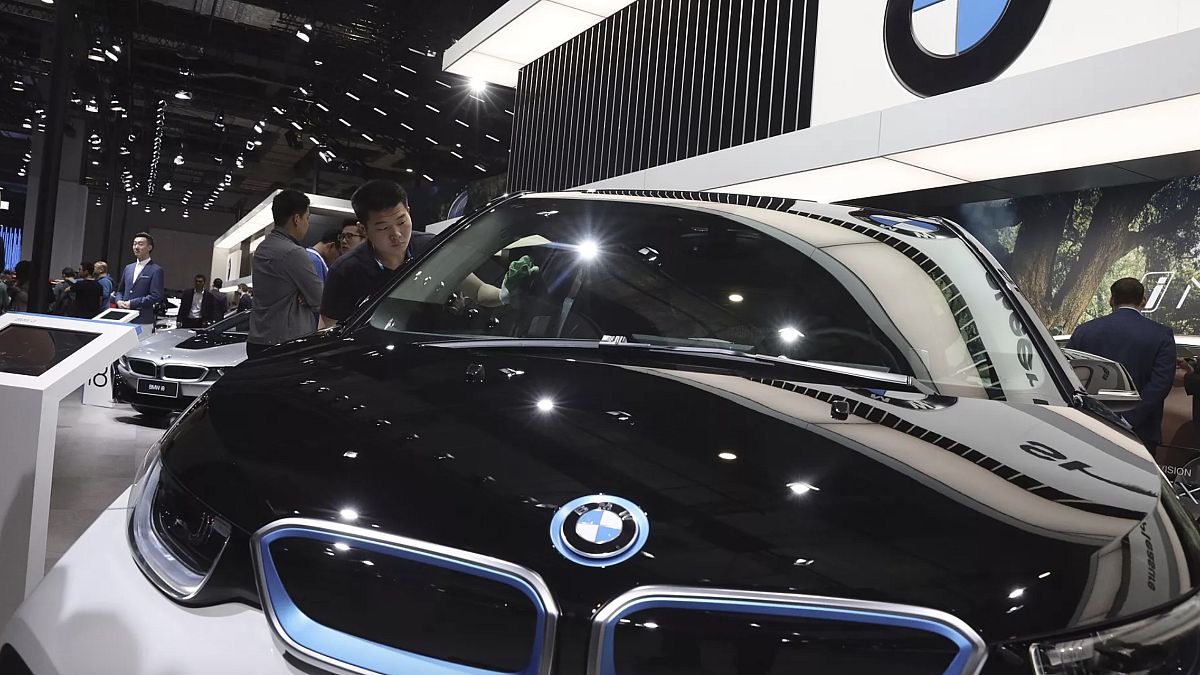 Bir kişi, Şangay'daki Auto Shanghai 2019 fuarı sırasında BMW standında elektrikli bir aracı temizliyor, 17 Nisan 2019.