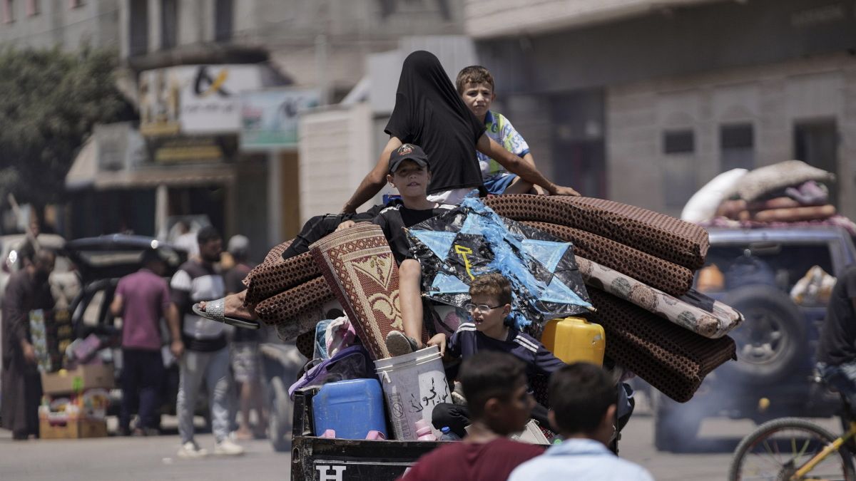 فلسطينيون يخلون مدرسة نزحوا إليها سابقاً، في شرق دير البلح، قطاع غزة، الجمعة، 16 أغسطس، 2024