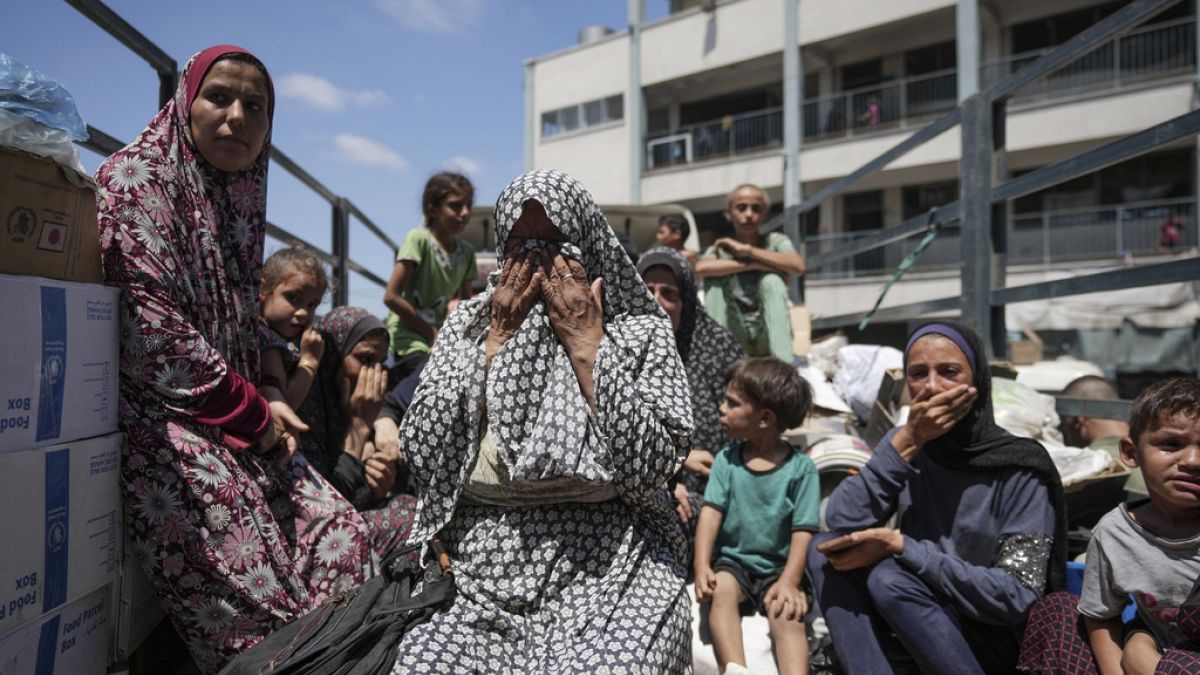 Des femmes palestiniennes pleurent sur un camion alors qu'elles évacuent une école qui leur servait d'abri, dans l'est de Deir al-Balah, dans la bande de Gaza, 16.08.2024.