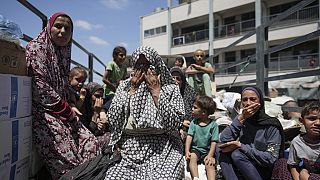 Des femmes palestiniennes pleurent sur un camion alors qu'elles évacuent une école qui leur servait d'abri, dans l'est de Deir al-Balah, dans la bande de Gaza, 16.08.2024.