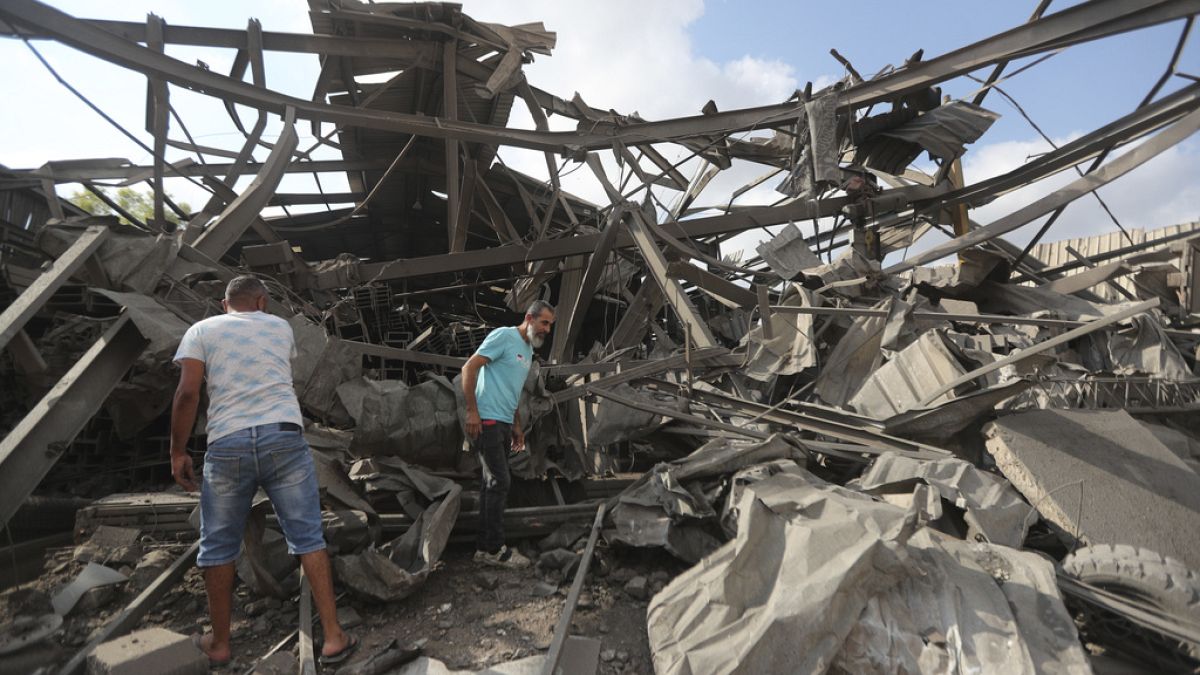 Men inspect an industrial area destroyed by an Israeli airstrike, in Wadi al-Kfour, Nabatieh province, south Lebanon, Saturday, Aug. 17, 2024.