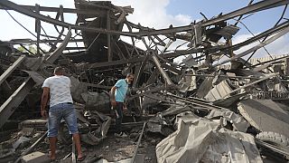 Men inspect an industrial area destroyed by an Israeli airstrike, in Wadi al-Kfour, Nabatieh province, south Lebanon, Saturday, Aug. 17, 2024.