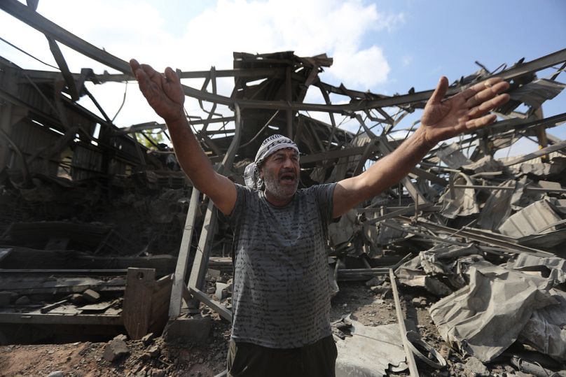 A man reacts at an industrial area destroyed by an Israeli airstrike, in Wadi al-Kfour, Nabatieh province, south Lebanon, Saturday, Aug. 17, 2024.