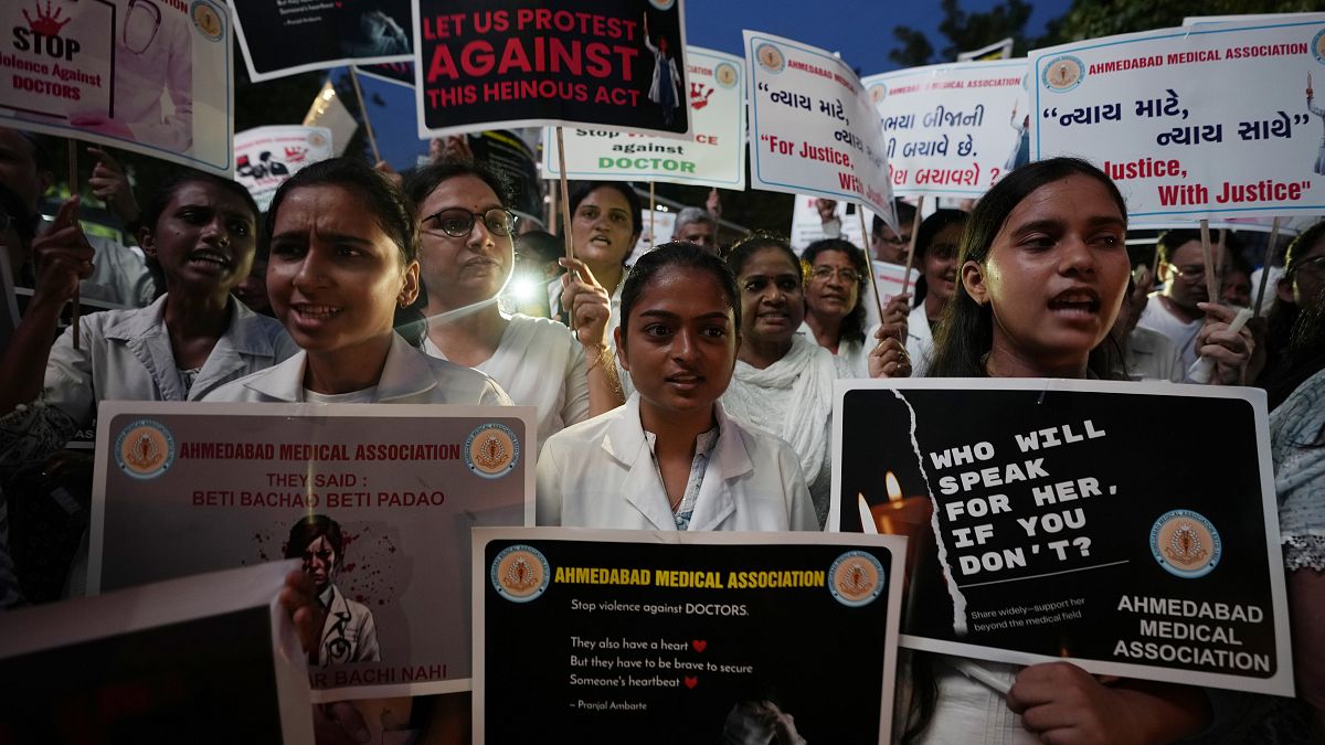 Doktorlar ve tıp öğrencileri, geçen hafta Kolkata'da stajyer bir doktorun tecavüz edilerek öldürülmesini protesto etmek için düzenlenen gösteride pankartlar ve mumlar tutuyor, 17 Ağustos 2024