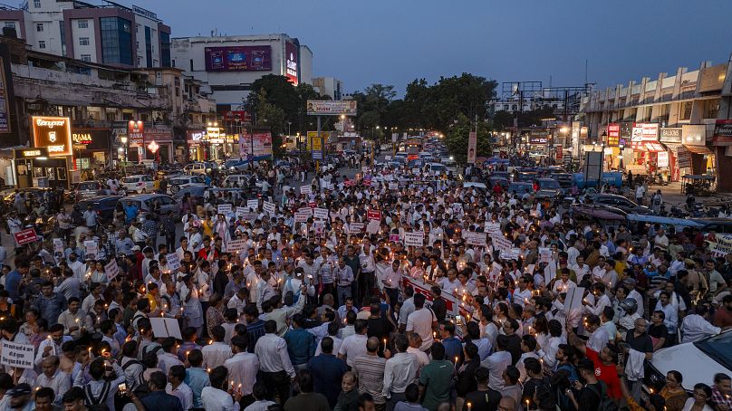 Medical staff hold candles and walk in a protest rally in Prayagraj against the rape and killing of a trainee doctor, August 17, 2024