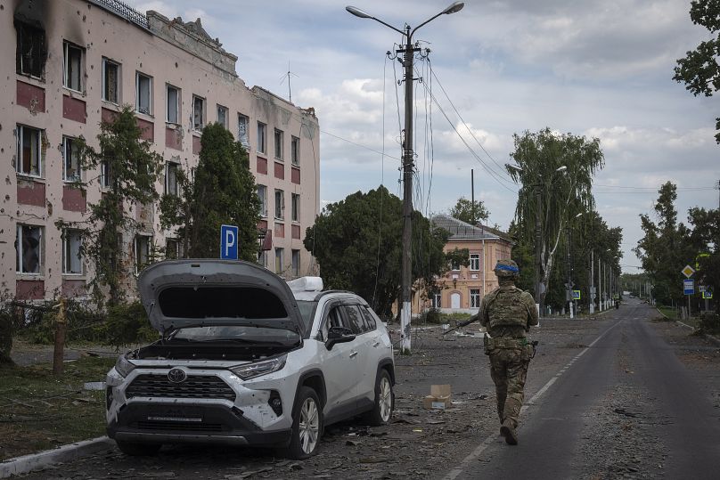 Un soldat ukrainien passe devant la mairie de Soudja, dans la région de Koursk, le 16 août 2024.