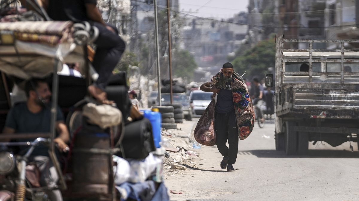 فلسطيني يحمل أغراضه أثناء إخلائه من مخيم المغازي للاجئين وسط قطاع غزة، في إطار عملية إجلاء جماعي أمر بها الجيش الإسرائيلي ، السبت 17 أغسطس/آب 2024