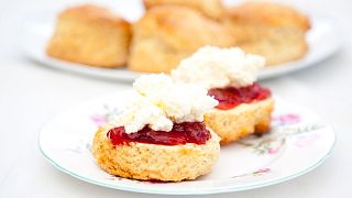 A scone with jam and cream on top, showing the 'Cornish method'