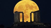 The super moon rises behind the Temple of Poseidon at Cape Sounio, south of Athens, Monday, Aug. 19, 2024.