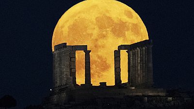 The super moon rises behind the Temple of Poseidon at Cape Sounio, south of Athens, Monday, Aug. 19, 2024.