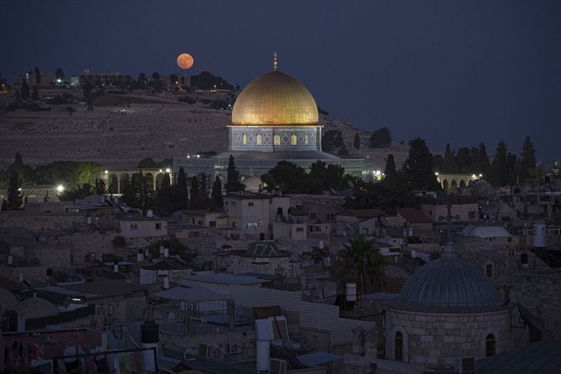 القمر العملاق خلف قبة الصخرة في المسجد الأقصى في البلدة القديمة بالقدس، الاثنين، 19 أغسطس، 2024.