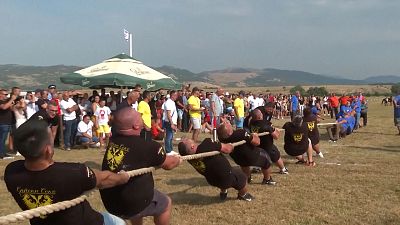 Two groups of men taking part in a tug of war rope competition 