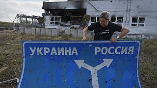 Ukrainian historian Yuri Savchuk, head of the Kyiv-based Ukrainian WWII history museum, carries a road sign in Sudzha, Kursk region, Russia, Friday, Aug. 16, 2024. This image 