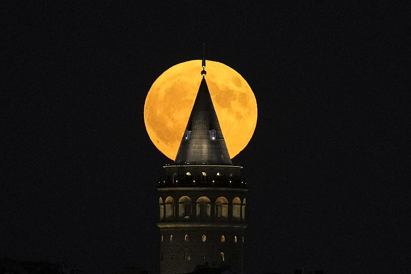 Une super lune se lève derrière la tour Galata à Istanbul, en Turquie, le lundi 19 août 2024.