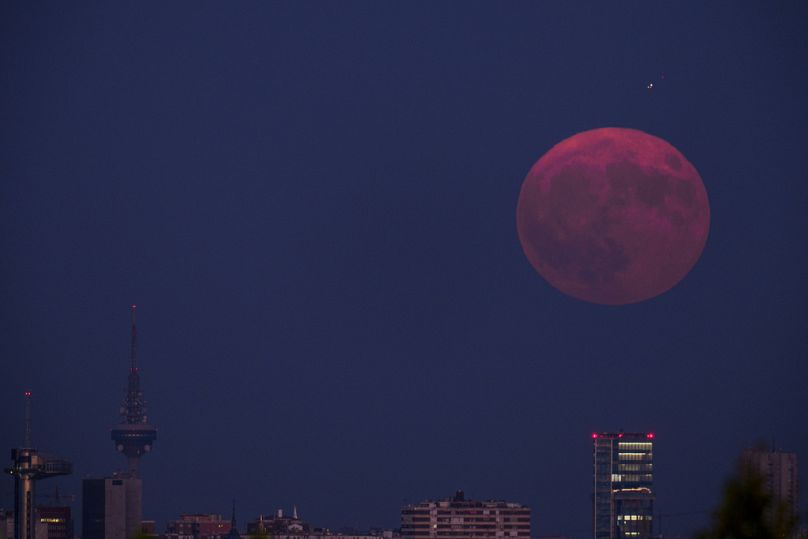 The supermoon rises over the skyline of Madrid, in Pozuelo de Alarcon, Spain, Monday, Aug. 19, 2024.